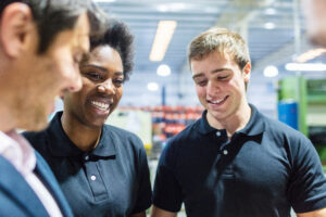 Worker In Meeting With Colleagues At Factory
