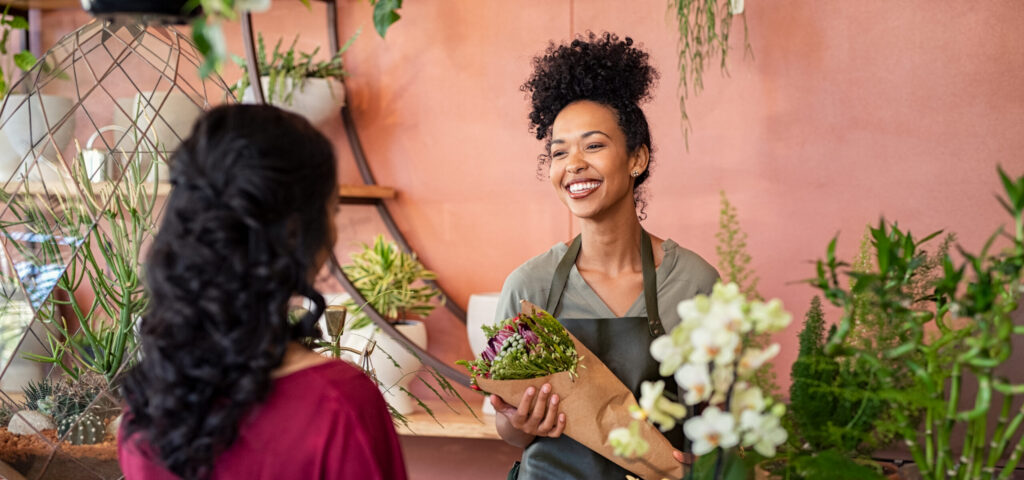 Happy Friendly Florist Giving Fresh Bouquet To Customer